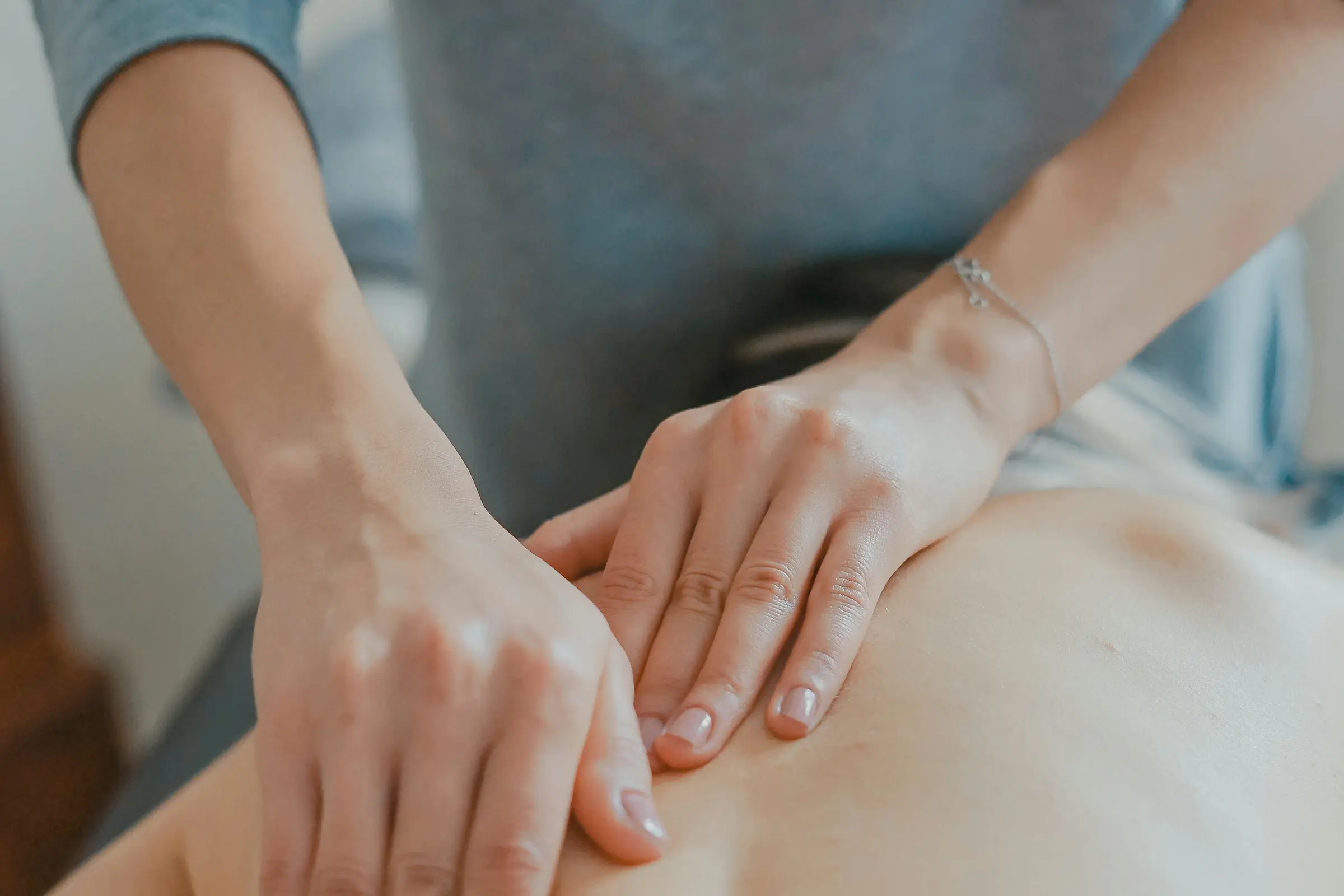 A therapist's hands working along a client's back during a massage