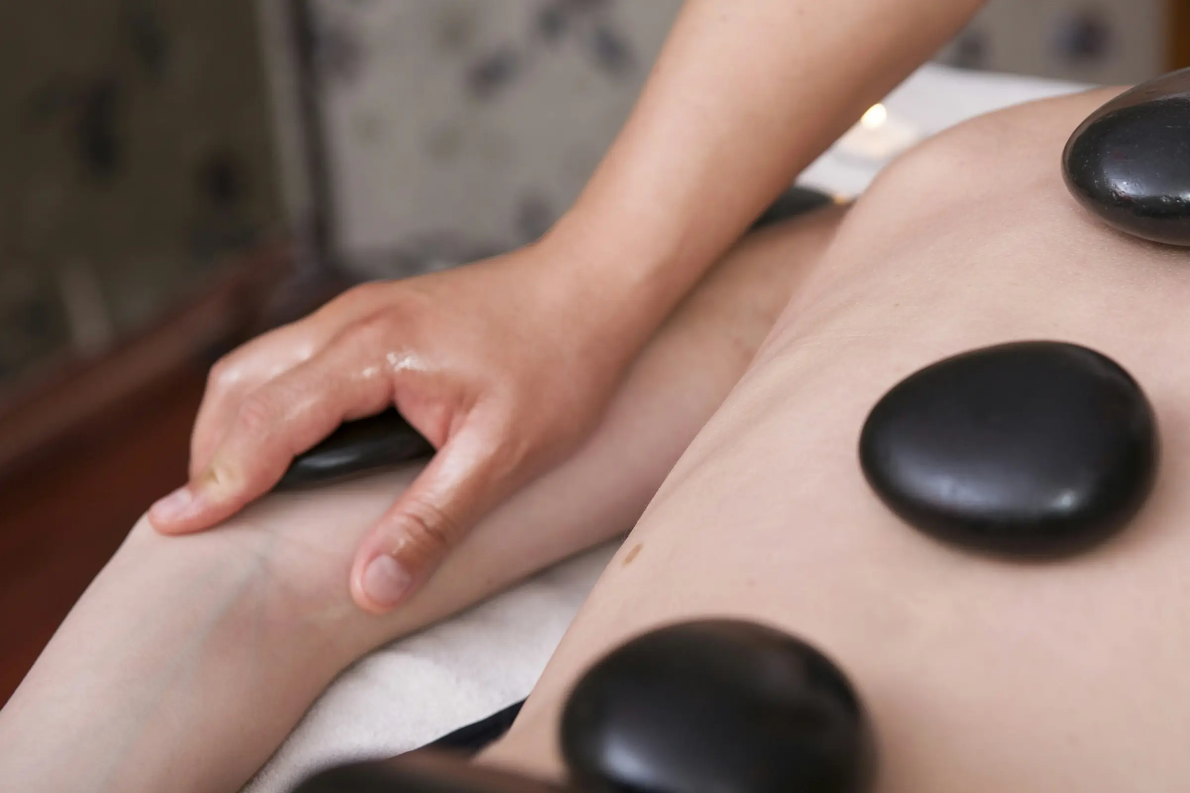 Smooth hot stones resting on a client's back during a massage