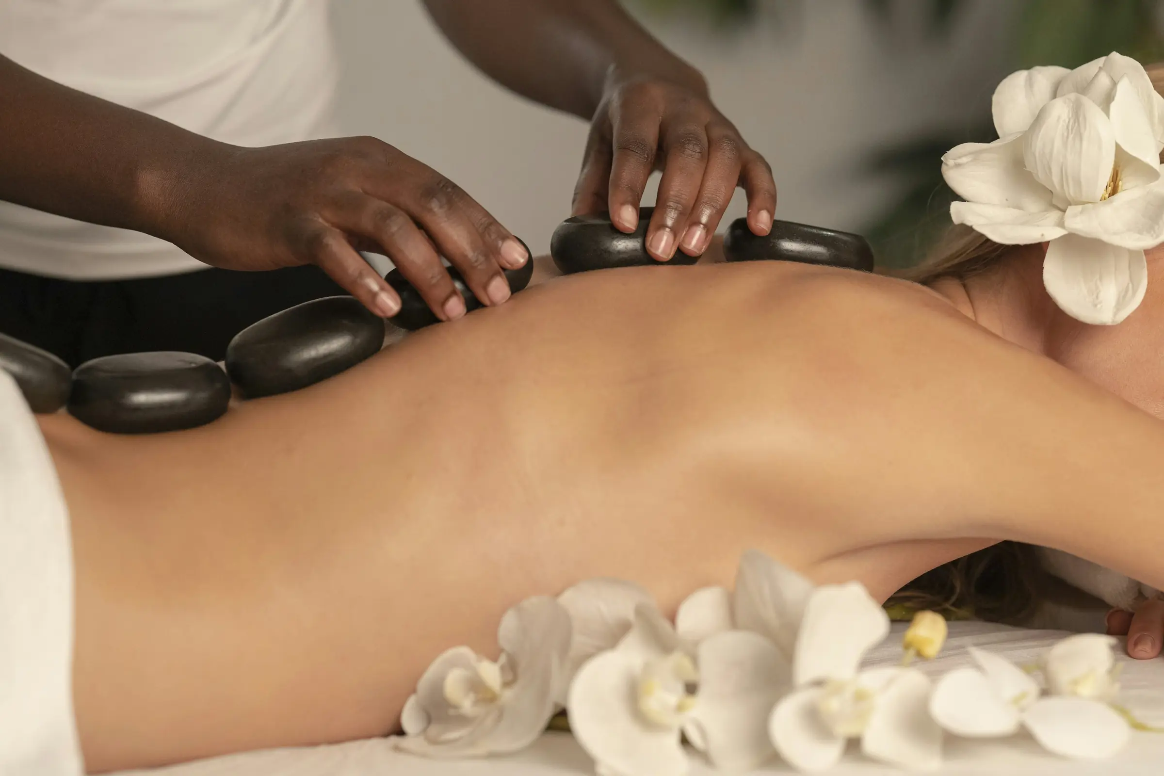 A therapist placing warm stones along a client's spine